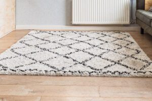 White rug with a black diamond pattern in the fibers
